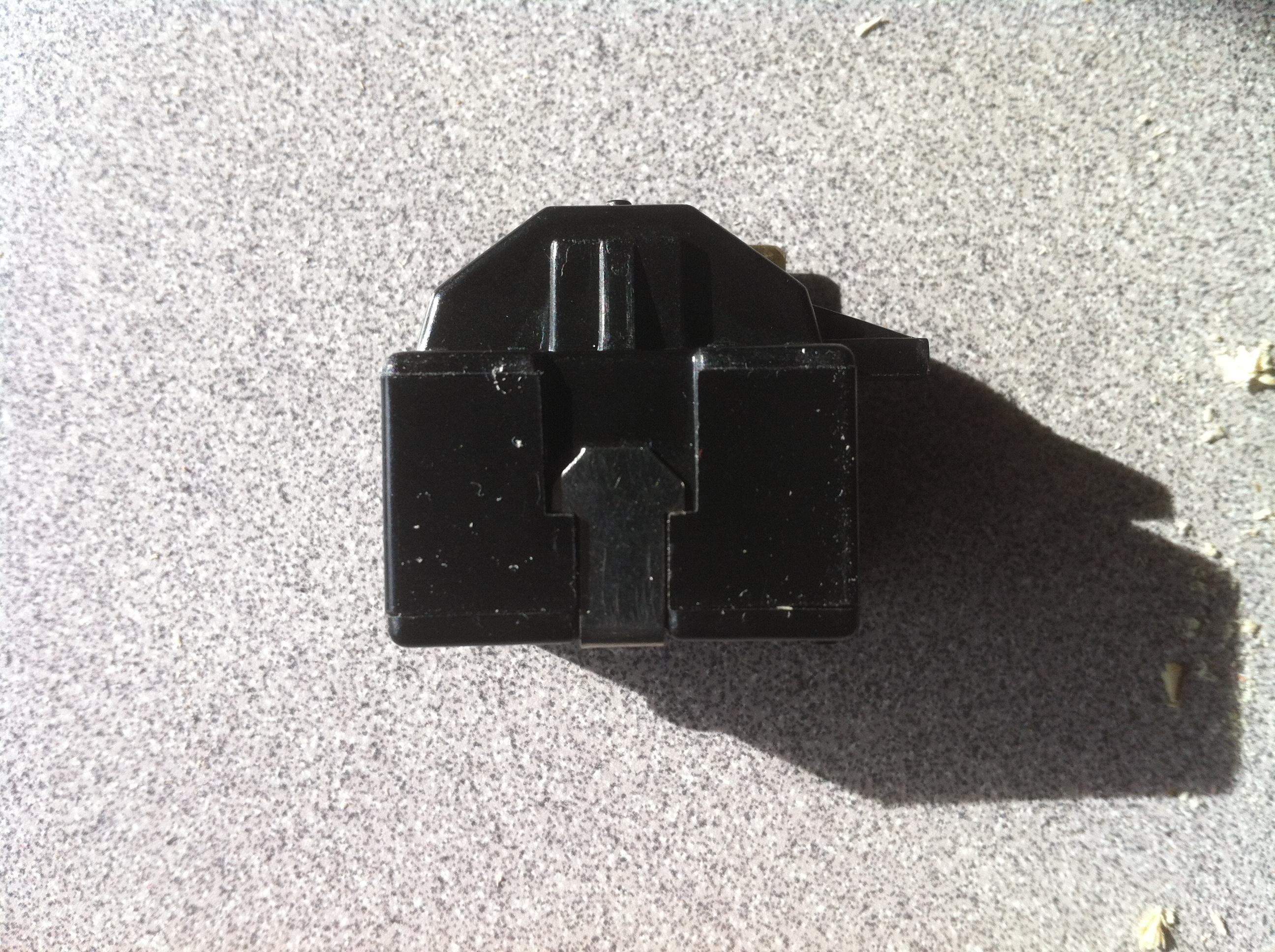 Rear view of a black P6R8MC PTC starter removed from a refrigerator compressor